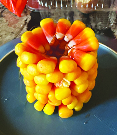 pieces of candy corner stacking in a circle to look like an ear of corn