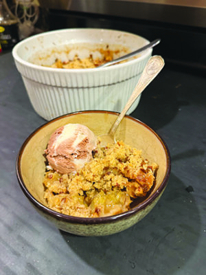 bowl of baked fruit crumble with scoop of ice cream