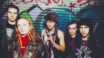 5 band members with grunge style standing in front of graffiti wall